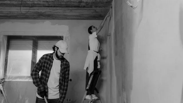 창문 테두리를 마스킹하고 벽에 페인트를 칠하는 사람들