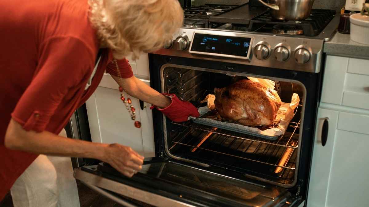 A woman taking food out of the oven