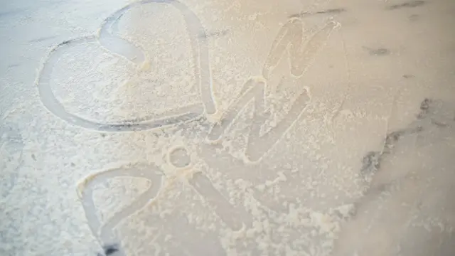 Flour spread on a cutting board with text written on it