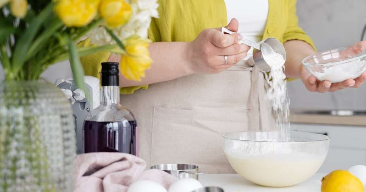 A woman cooking while wearing an apron