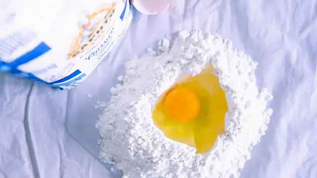 Egg cracked onto flour before mixing