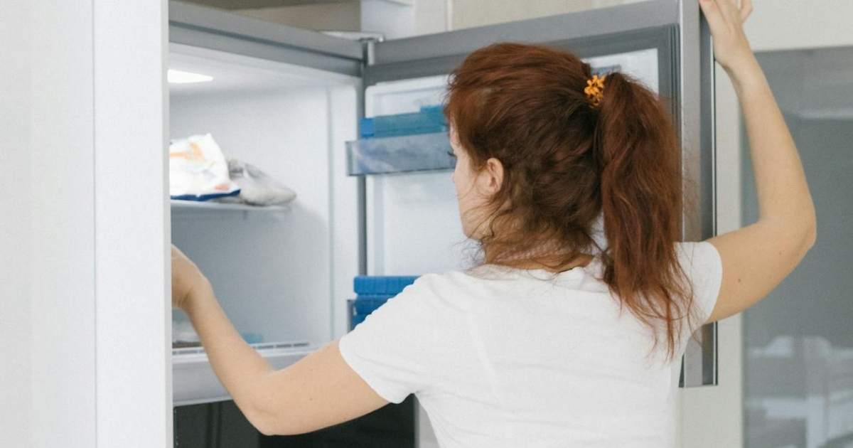 A woman taking ingredients out of the refrigerator in the kitchen